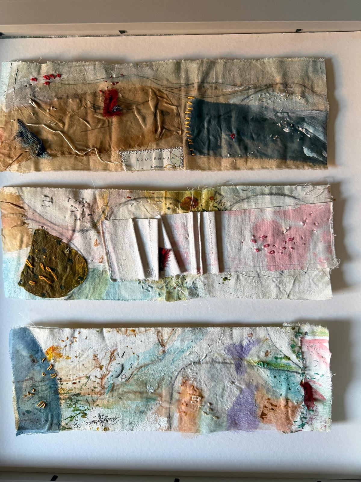 Three horizontal stitched paper and fabric studies in soft grey, blue, blush and ochre